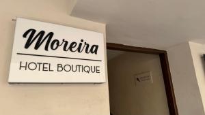 a sign for a hotel boutique hanging on a wall at Moreira Hotel Boutique in Mérida
