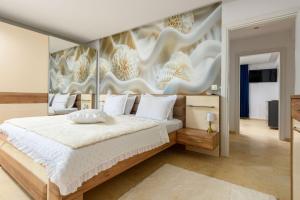 a bedroom with a large bed with a painting on the wall at Oasis deluxe apartments in Skala Rachoniou +71 photos