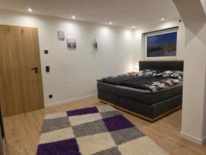 a bedroom with a black bed and a rug at Kleines Apartement in Rednitzhembach