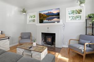 a living room with a fireplace and a tv on the wall at Charming 1930s Style Rustic Home in Eugene