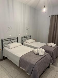 two beds in a bedroom with towels on them at Sidari Centre Apartments in Sidari