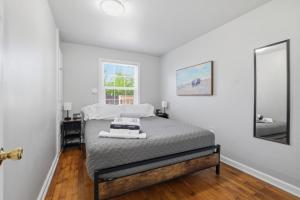 a white bedroom with a bed and a mirror at Charming 1930s Style Rustic Home in Eugene