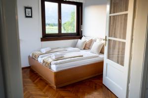 a bed in a room with a window at Entire Villa for 6 near Bled -Private Garden, Grill & Free Parking in Lesce