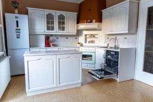 a white kitchen with white cabinets and a dishwasher at Entire Villa for 6 near Bled -Private Garden, Grill & Free Parking in Lesce