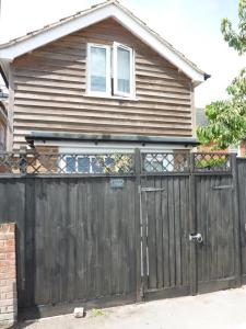 a house with a wooden gate in front of a house at Eastern Lodge 11B in Lymington