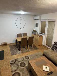 a living room with a table and a clock on the wall at House Apartment Azra in Sarajevo