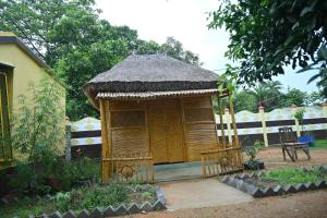 a small hut with a thatched roof in a yard at Bagan Bilas Homestay in Jhilimili