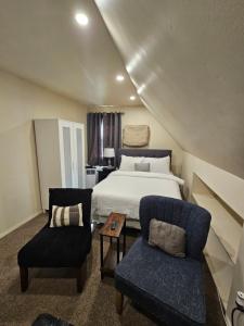 a bedroom with a bed and a couch and a chair at Cozy 111 in Elmont