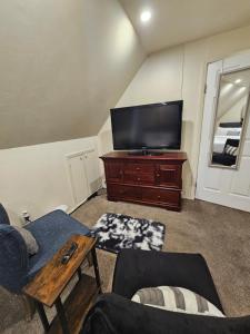 a living room with a flat screen tv on a dresser at Cozy 111 in Elmont