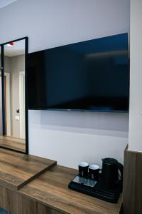 a large flat screen tv on a wall with two coffee mugs at Oribu Boutique Hotel Vlore in Vlorë +30 photos