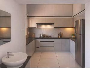 a white kitchen with a sink and a refrigerator at Private 3 BHK home in Central Trivandrum with free parking in Trivandrum