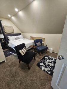 a bedroom with a bed and two chairs at Cozy 111 in Elmont