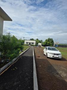 a white car parked on the side of a road at Kohli Farms in Gof
