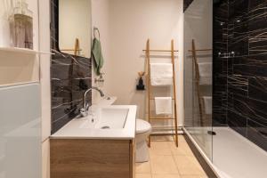 a bathroom with a sink and a toilet and a shower at Cœur de Fontainebleau in Fontainebleau +18 photos