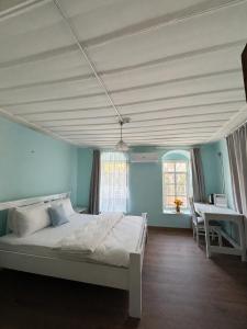a bedroom with a bed and a table and a window at Ayvalık 1892 Konukevi in Ayvalık