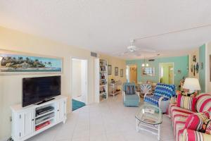 a living room with a couch and a flat screen tv at Martinique 401S in Holmes Beach +20 photos
