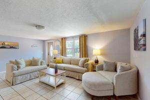 a living room with two couches and a table at Getaway on Gladiolus in Anna Maria