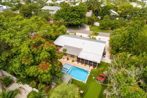 an aerial view of a house with a swimming pool and trees at Getaway on Gladiolus in Anna Maria