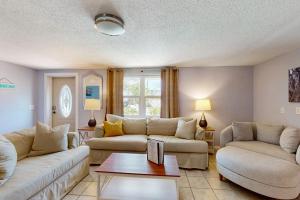 a living room with two couches and a table at Getaway on Gladiolus in Anna Maria +23 photos