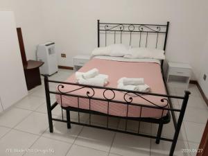 a bedroom with a bed with pink sheets and towels at FLOWER-House in Anzio