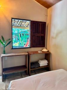 a bedroom with a bed and a mirror and a window at Mar de Moreré in Cairu