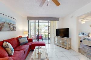 a living room with a red couch and a flat screen tv at Shorewalk Villa in Bradenton