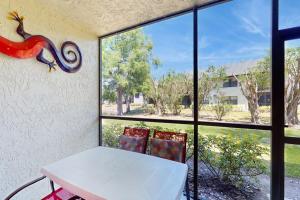 a table and two chairs in a room with windows at Shorewalk Villa in Bradenton