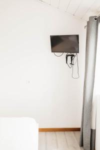 a wall mounted tv in a room with a pole at Casa do Foral by Lethes Legacy in Ponte de Lima
