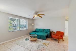 a living room with a blue couch and two chairs at Gertie's Coconut House in Holmes Beach