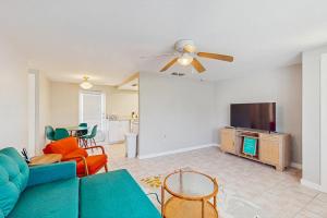 a living room with a couch and a flat screen tv at Gertie's Coconut House in Holmes Beach