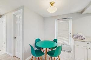 a dining room with a green table and chairs at Gertie's Coconut House in Holmes Beach