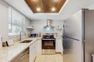 a kitchen with a stainless steel refrigerator and a sink at Gertie's Coconut House in Holmes Beach