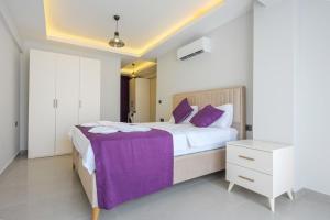 a bedroom with a large bed with purple sheets at Villa A1 Canpare in Fethiye +32 photos