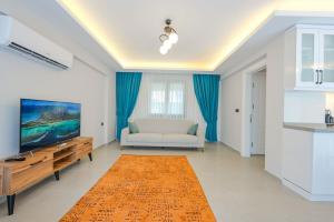 a living room with a couch and a television at Villa A1 Canpare in Fethiye