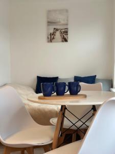 a table with three blue cups on top of it at Błękitna Fala in Ustka