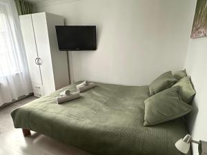 a bedroom with a bed with a tv on the wall at Błękitna Fala in Ustka
