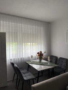 a dining room with a table and chairs with flowers on it at Bella stan na dan in Široki Brijeg