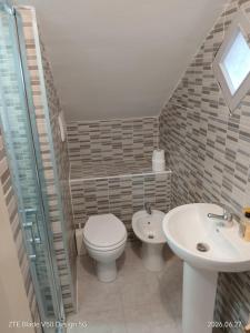 a bathroom with a toilet and a sink at FLOWER-House in Anzio +13 photos