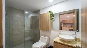 a bathroom with a toilet and a sink and a shower at Parque de La 93 - Elite Flats in Bogotá +43 photos