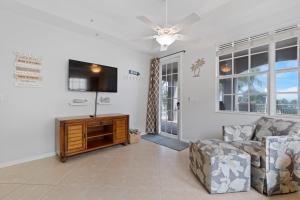 a living room with a couch and a flat screen tv at White Cap Condo B201 by Sun Palace Vacations in Fort Myers Beach