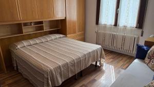 a room with a bed with a blanket on it at Alloggi Al Giardino & La Suite in Occhiobello