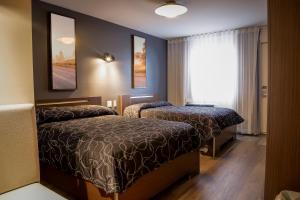 une chambre d'hôtel avec deux lits et une fenêtre dans l'établissement Complexe Hotelier Le 55, à Bécancour 29 autres photos