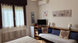 a living room with a couch and a television at Alloggi Al Giardino & La Suite in Occhiobello