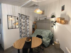 a small living room with a table and a bed at Cozy studio - proche Cité de Carcassonne in Couffoulens