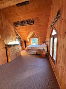 a bedroom with a bed in a wooden cabin at Casa Quento in Castro