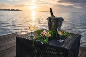 a table with two glasses of wine and a bucket at Villa Manatini in Papeete