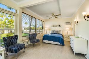 a bedroom with a bed and two chairs at Sandy's Getaway in Anna Maria +25 photos
