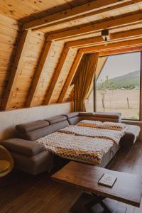 a living room with a couch and a large window at Sunrise House in Plužine