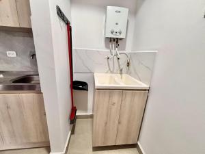 a small kitchen with a sink and a red mop at Posada del Quindío 0219 in Armenia