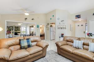 a living room with two brown leather couches and a kitchen at Bella Villa in Bradenton